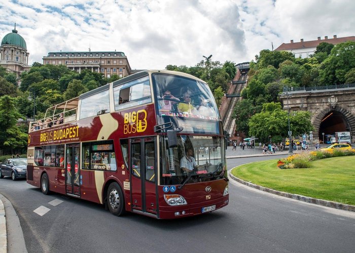 Big Bus Tours in Budapest crossing the Chain Bridge with views of Buda Castle, the Parliament Building, and the Danube River