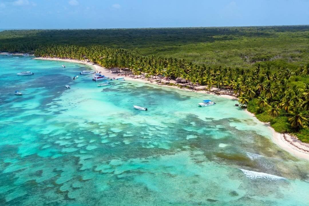 Caribbean cruise deal with a ship sailing through turquoise waters toward lush tropical islands, white-sand beaches, and vibrant coastal ports