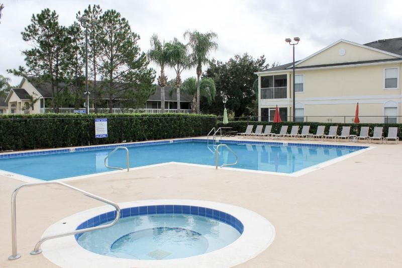 Large heated pool, hot tub and plenty of seating located just outside of unit