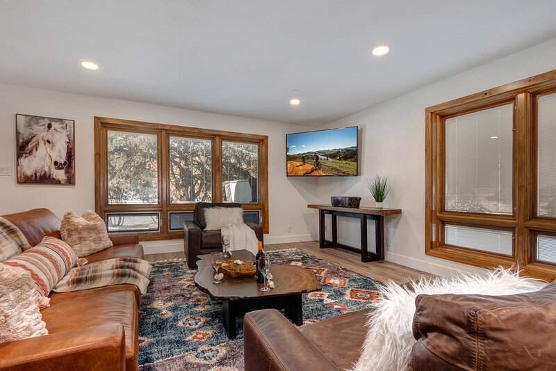 Living room with sleeper sofa, wet bar and beverage fridge, two-sided Gas Fireplace and 65" LG Smart TV